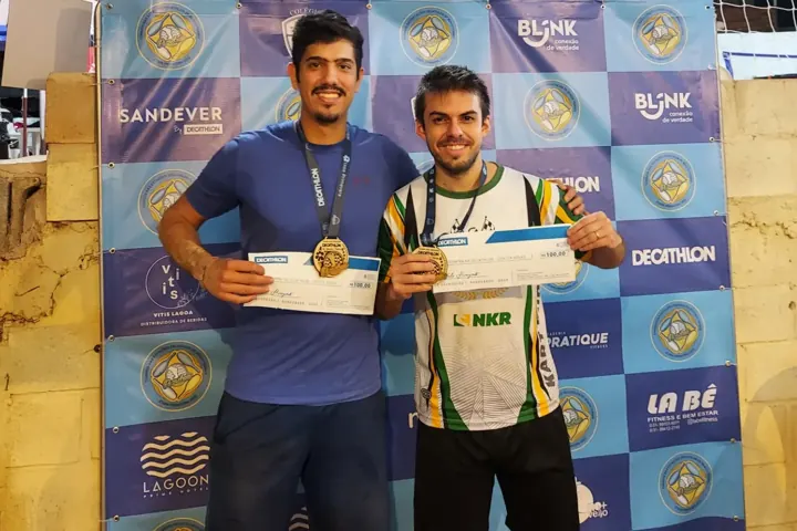Bruno Cândido Barroso, à direita, com a medalha e o prêmio de campeão num torneio de beach tennis, ao lado do parceiro de dupla