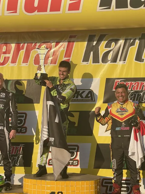 Bruno Cândido Barroso ergue o troféu no alto do pódio do campeonato nacional de kart rental da CBKA, em 2022